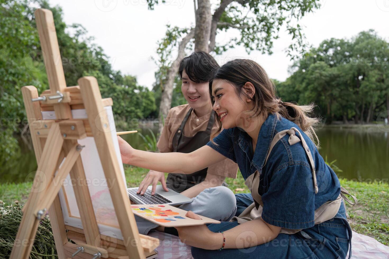 Romantic Couple Enjoying a Picnic While Drawing and Painting Outdoors in a Serene Park Setting photo