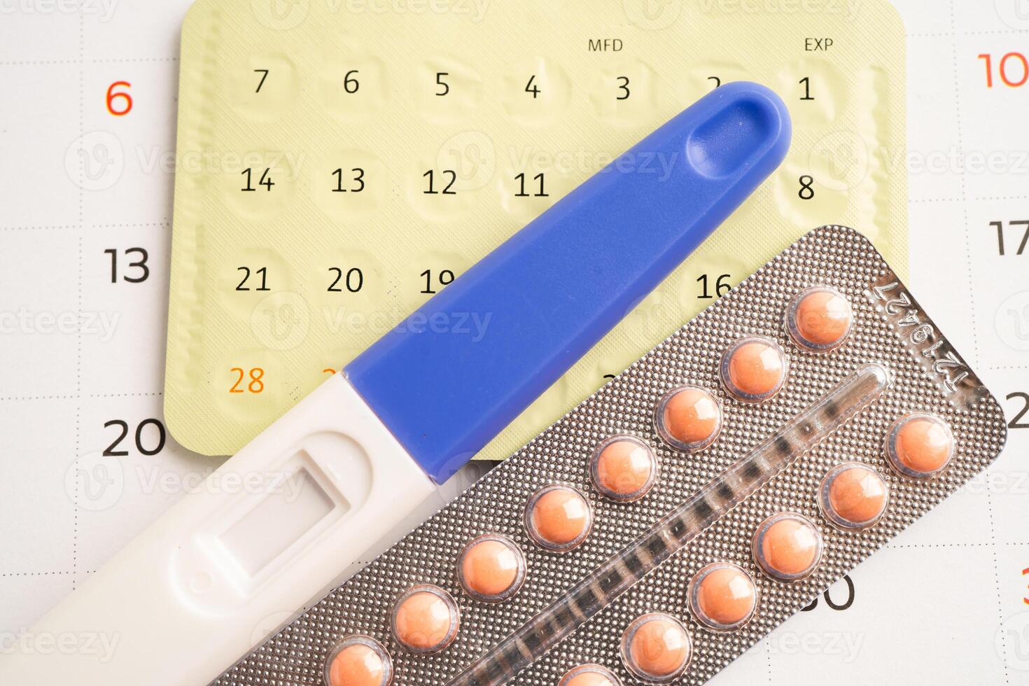 Pregnancy test and birth control pills on calendar, contraception health and medicine. photo