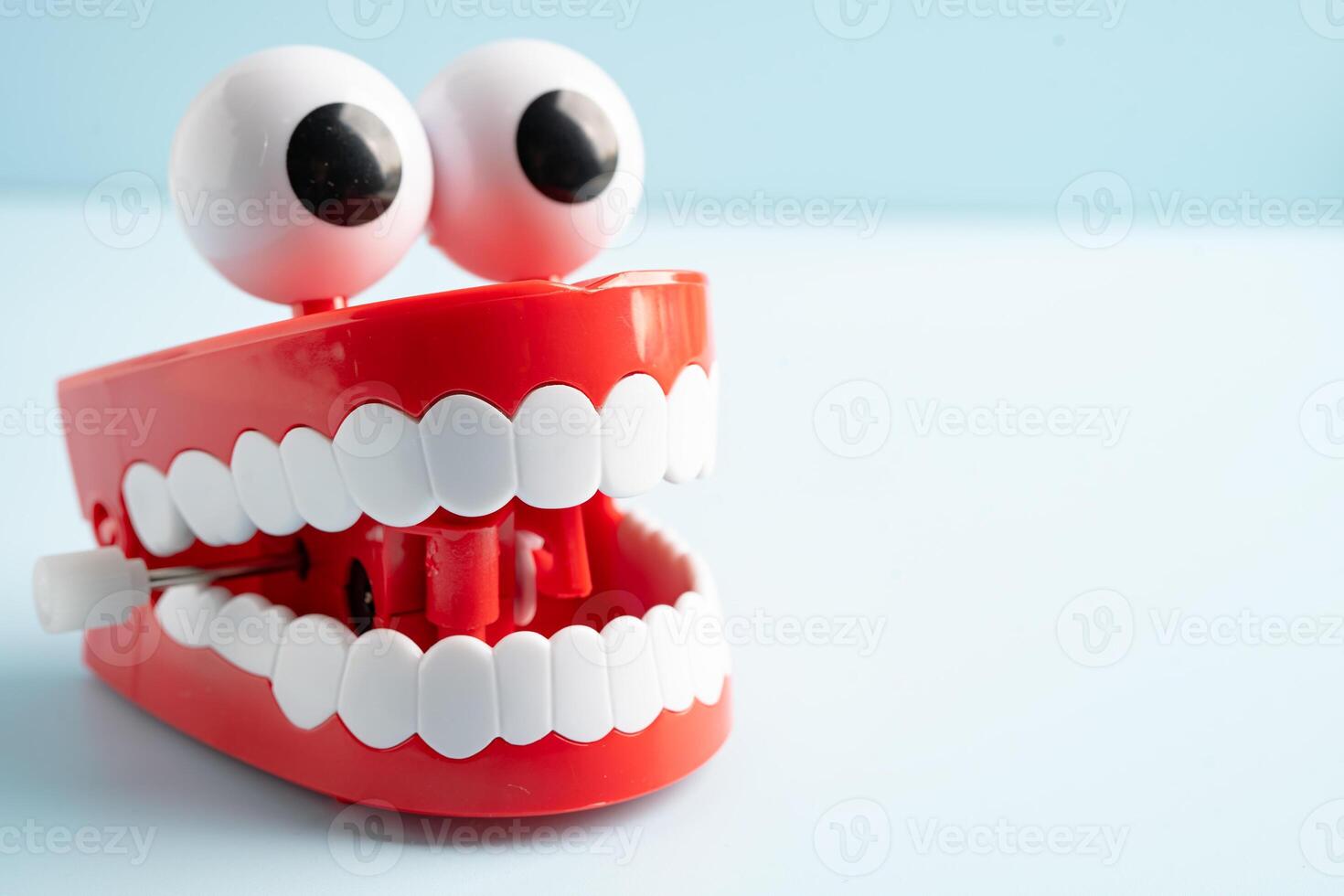 Tooth funny toy denture red color jaw and eye on white background with copy space. photo