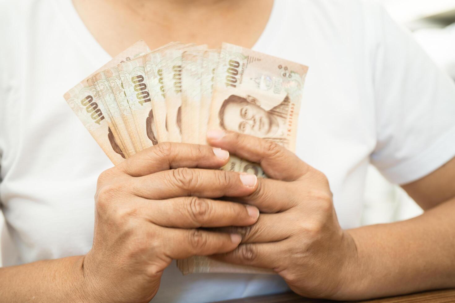 Asian business woman holding Thai banknote currency money. photo
