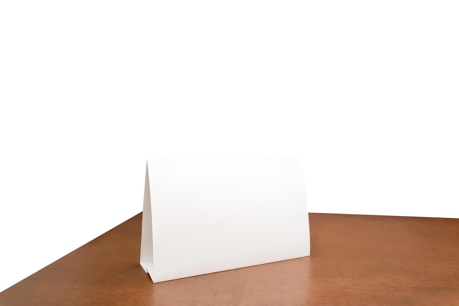 White paper sheet tent card on wooden table white isolated background can insert customer message. clipping path. Stand mockup frame menu card photo
