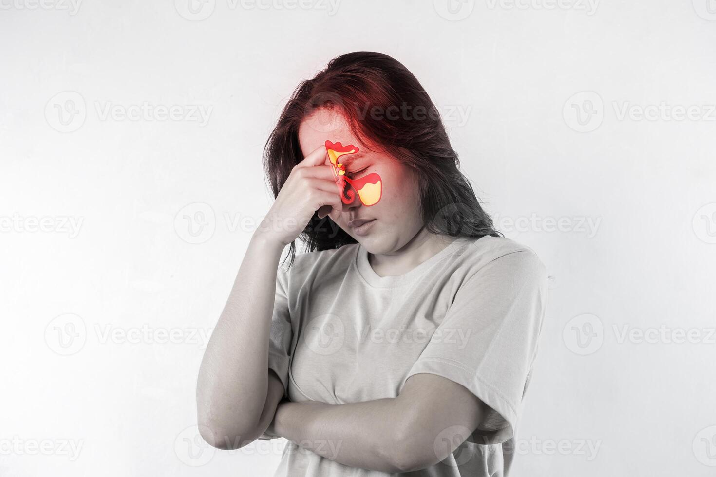A woman with a red nose and red eyes. She has her hands on her head. Sinusitis, frontitis. photo