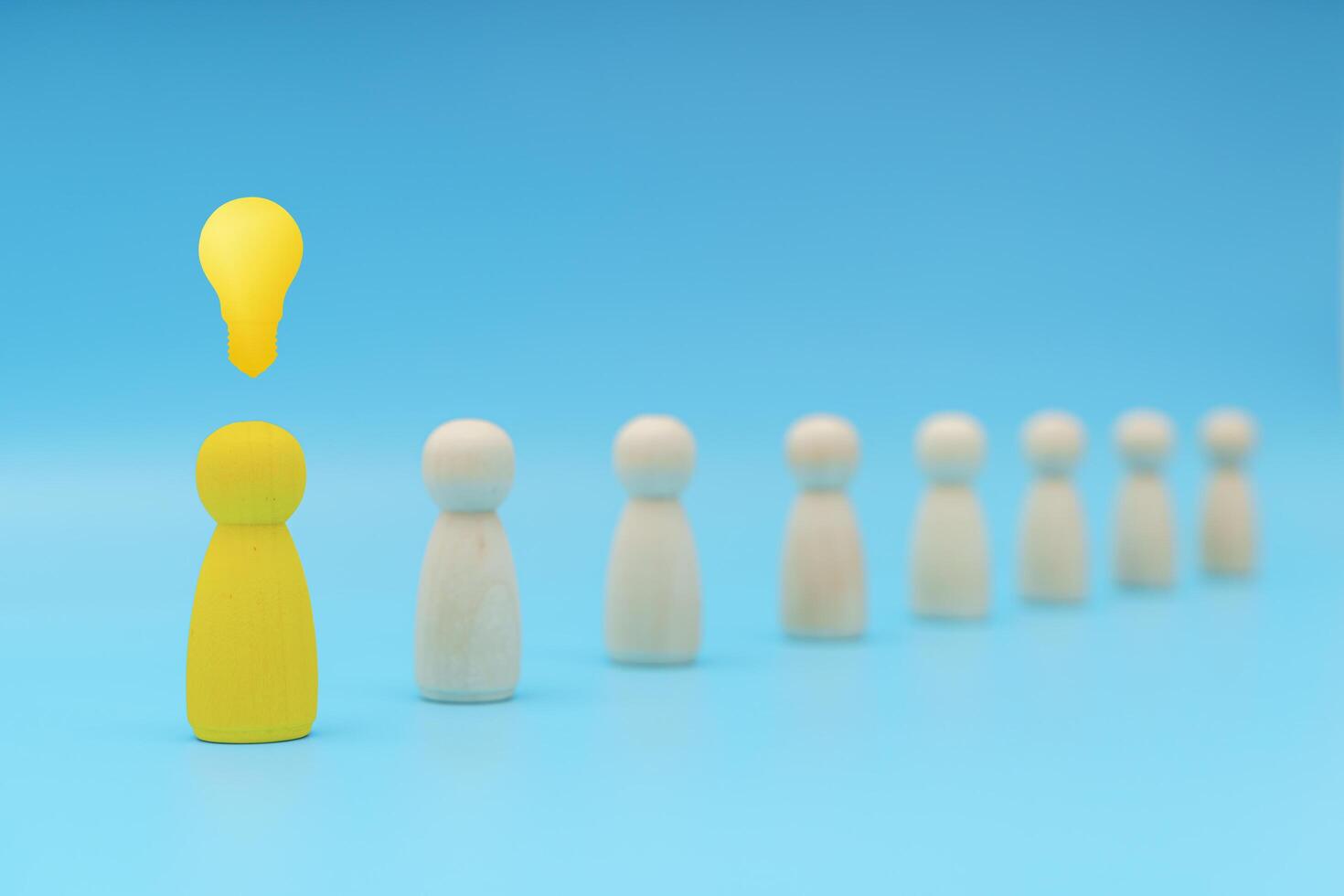 Outstanding yellow people standing with light bulb icon out from the crowd. Human resource, Talent management. photo