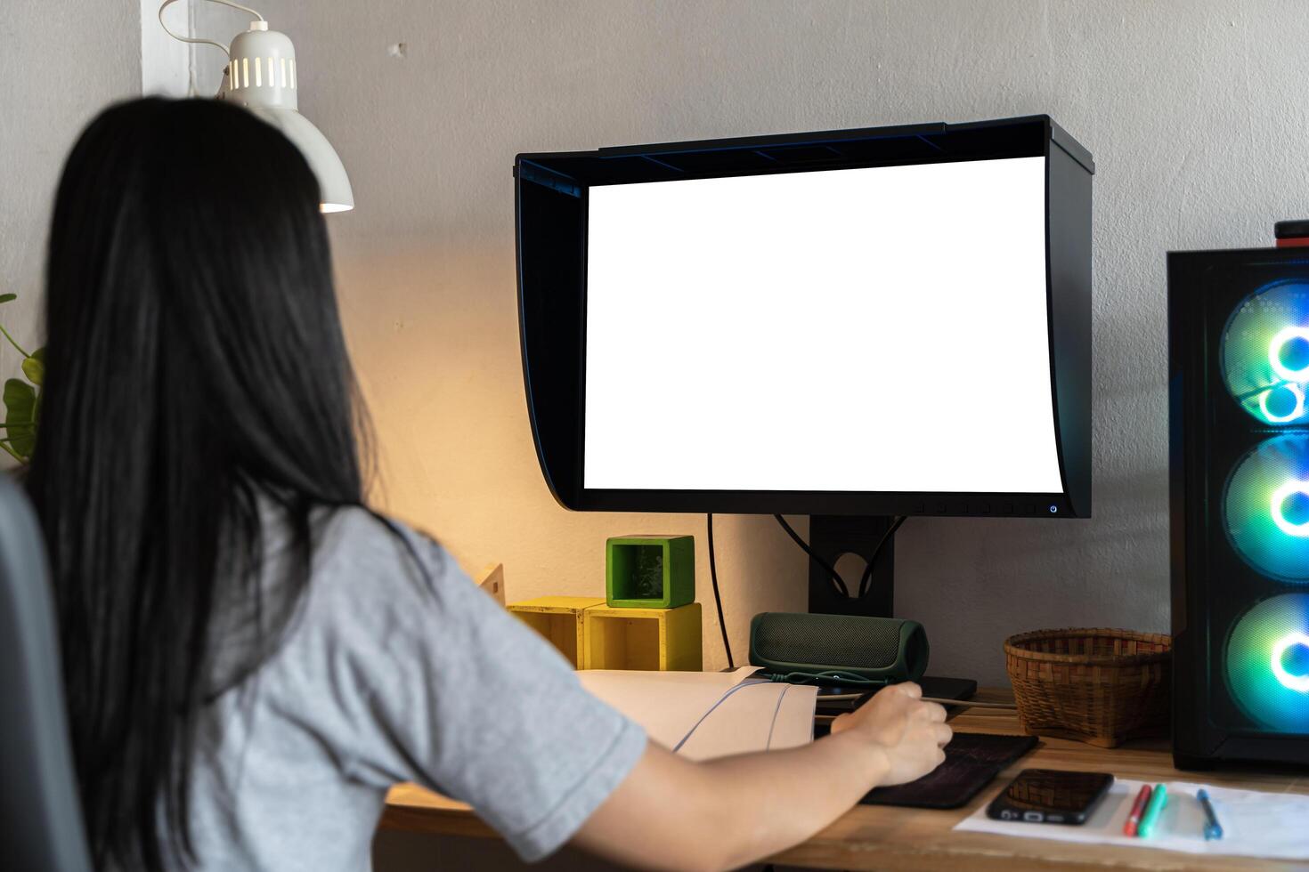 Mockup image of a woman using desktop computer with blank screen on wooden table. Female writer keyboarding photo