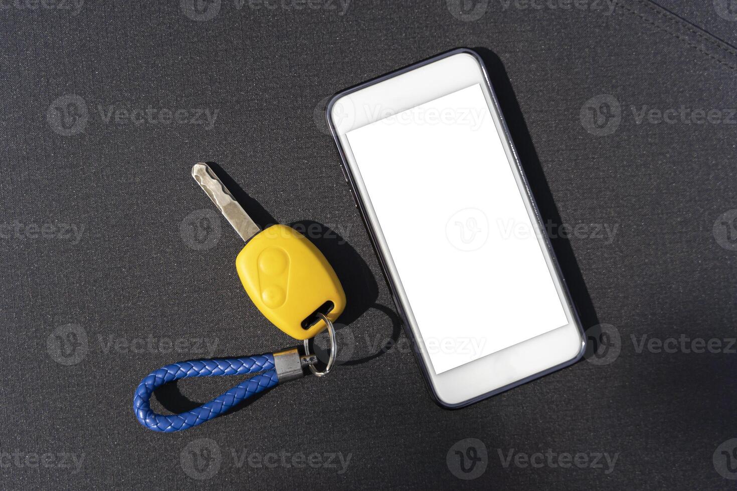 Car key. Auto remote control, flip key on a mobile phone, black background. Vehicle engine start, doors and trunk open and close. photo