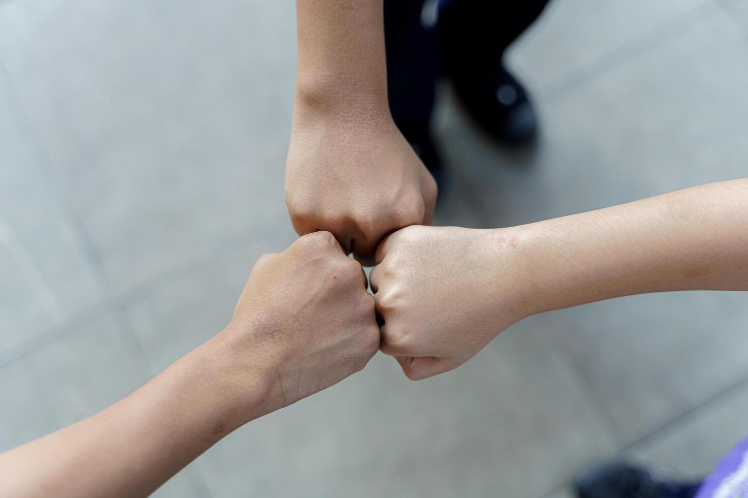 Close up of students standing hands making fist bump gesture. photo