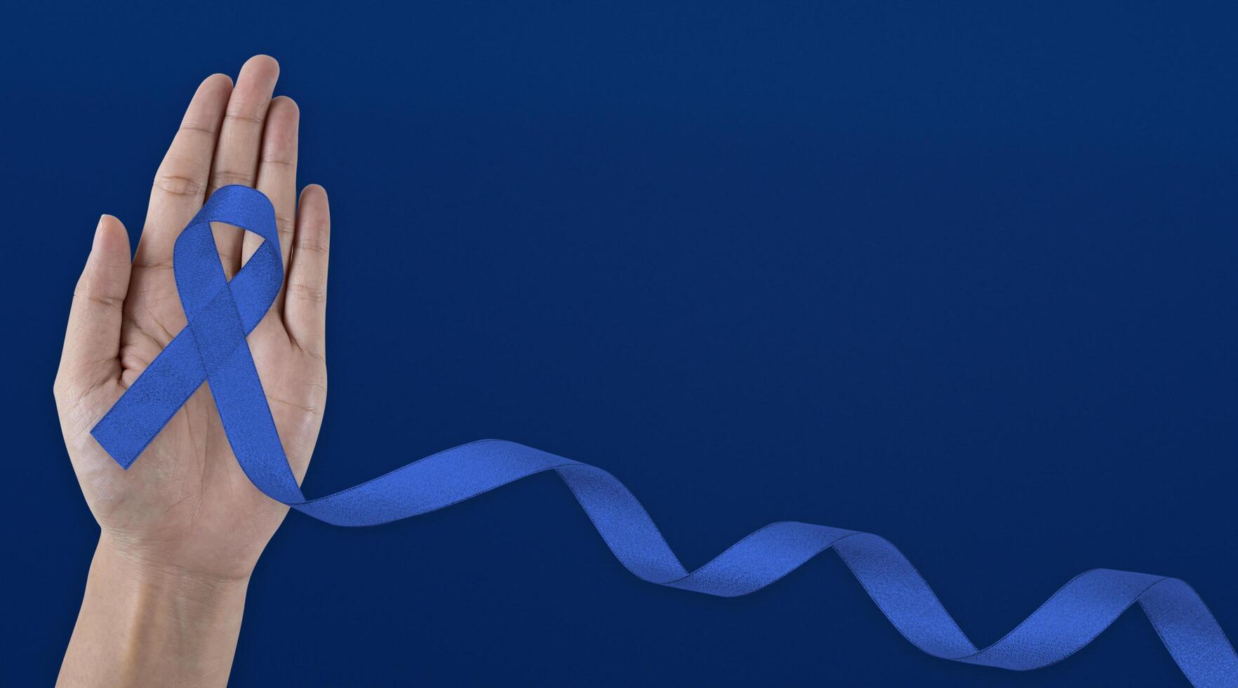 Man holding dark Blue Ribbon for supporting people living and illness. Healthcare, hope and World cancer day concept photo