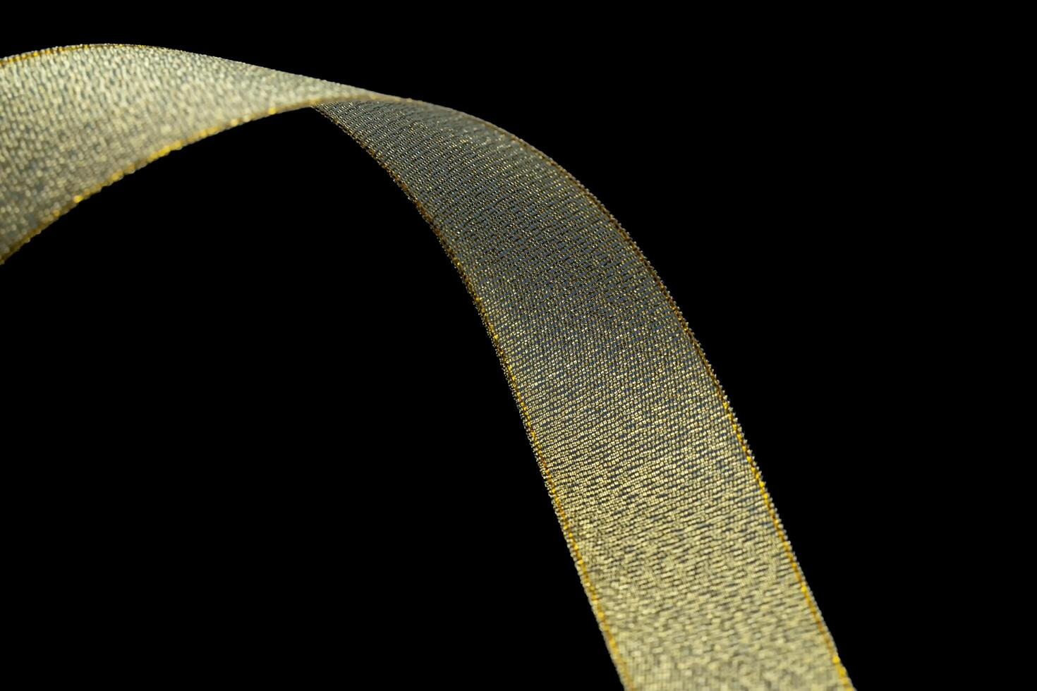 Gold gift wrap ribbon on black fabric background. Holiday, gold fabric ribbon on black background. With copyspace. photo