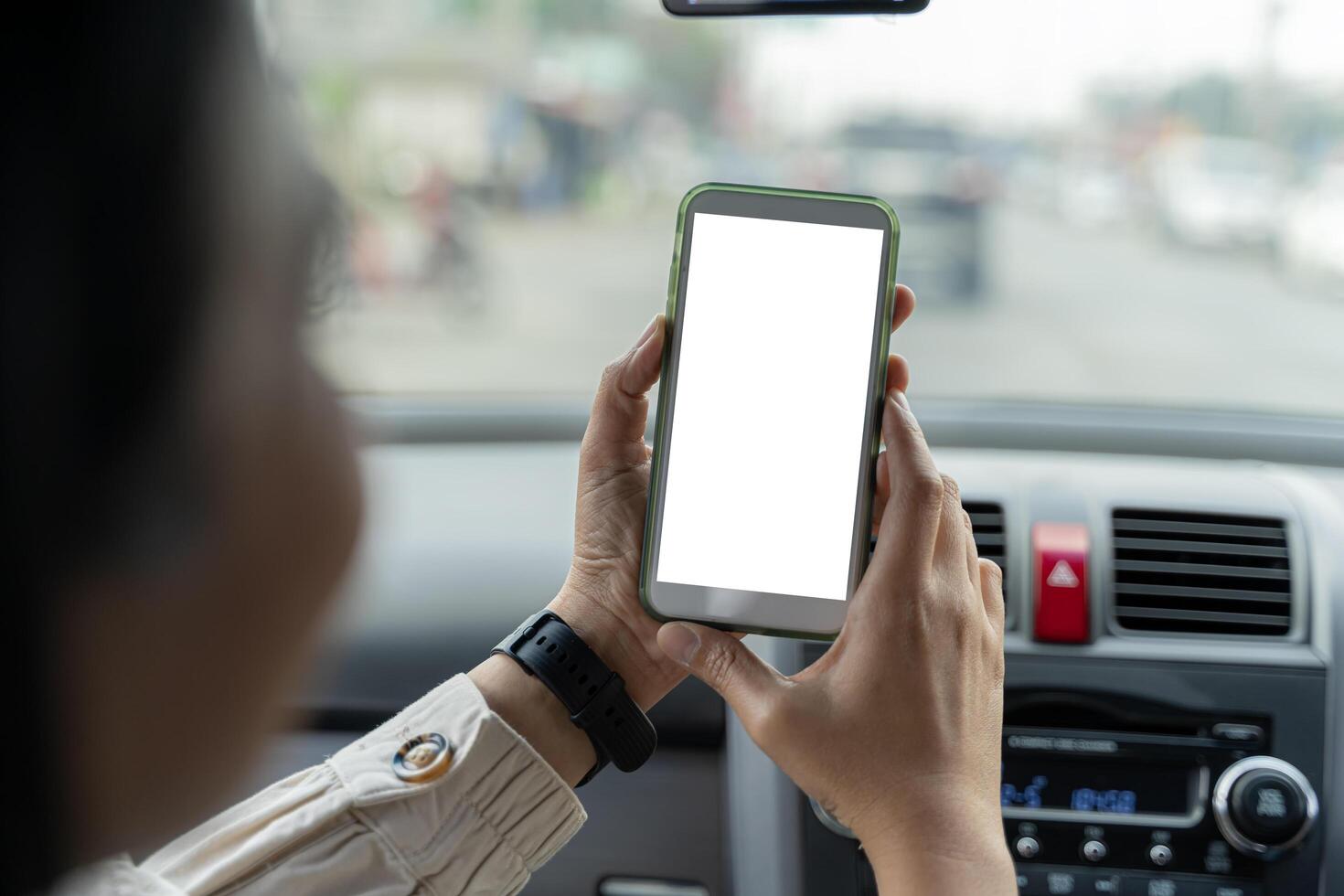 Happy couple using showing smartphone with empty screen, using mobile phone to look through navigation map during car trip photo