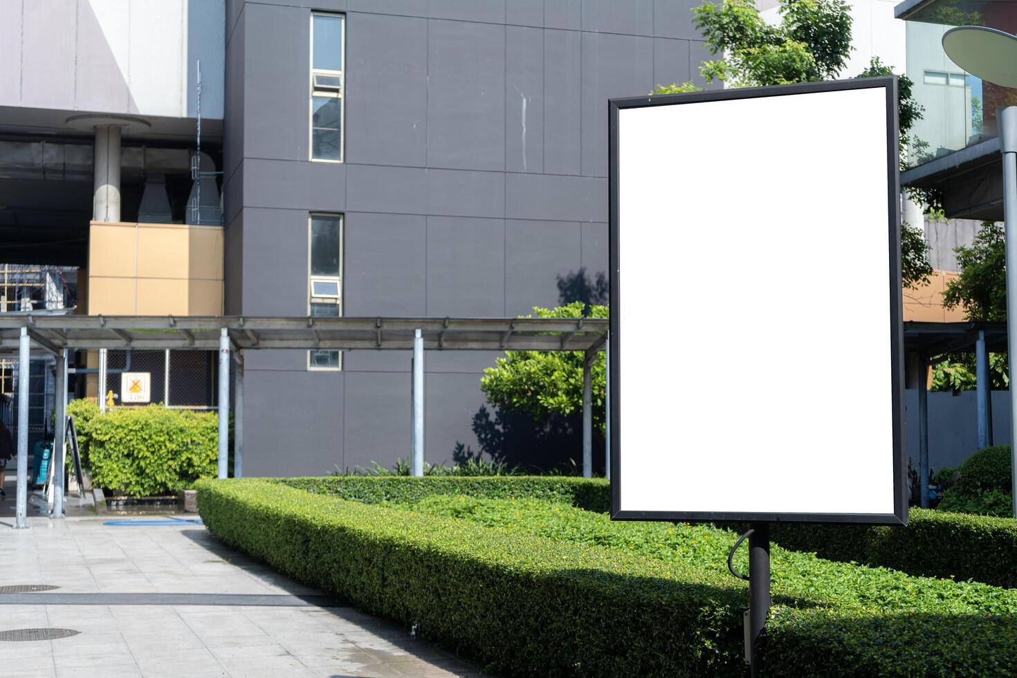 Mock up outdoor signboard on black stand with clipping path on walkway, empty space for insert advertising or graphic design. photo