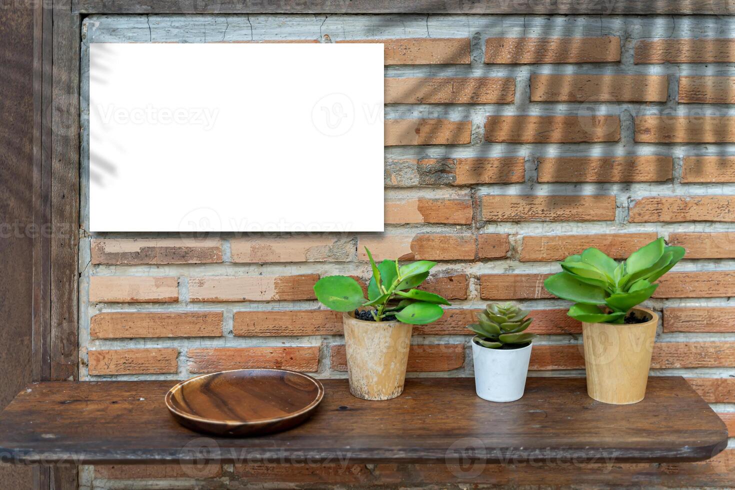A white sign on a red brick wall is installed at the entrance of a restaurant or cafe. The shadow of the leaves on the wall photo