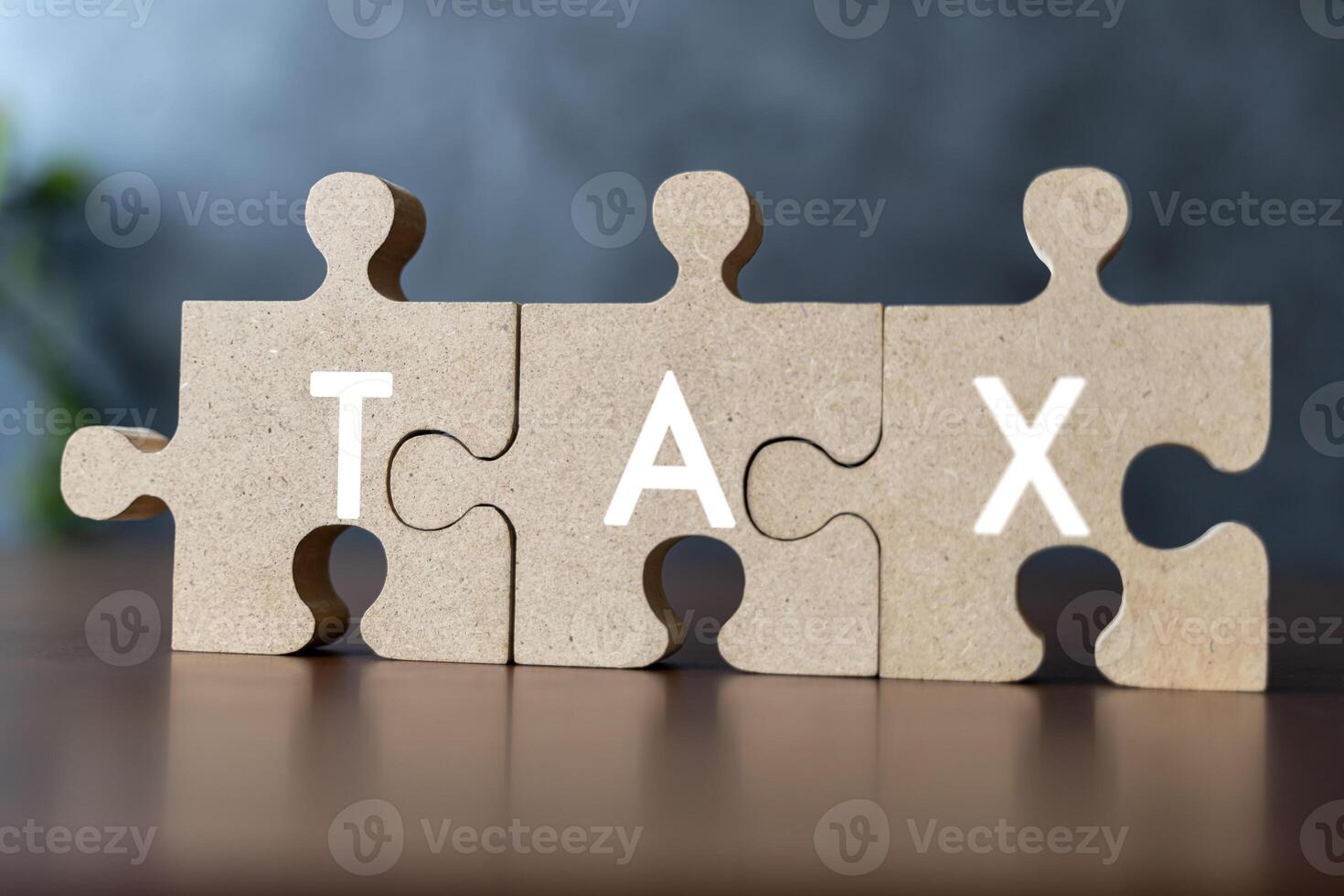 Taxes concept with wooden puzzle on a desk. Jigsaw puzzle as the task of putting together a complicated tax return each year. photo