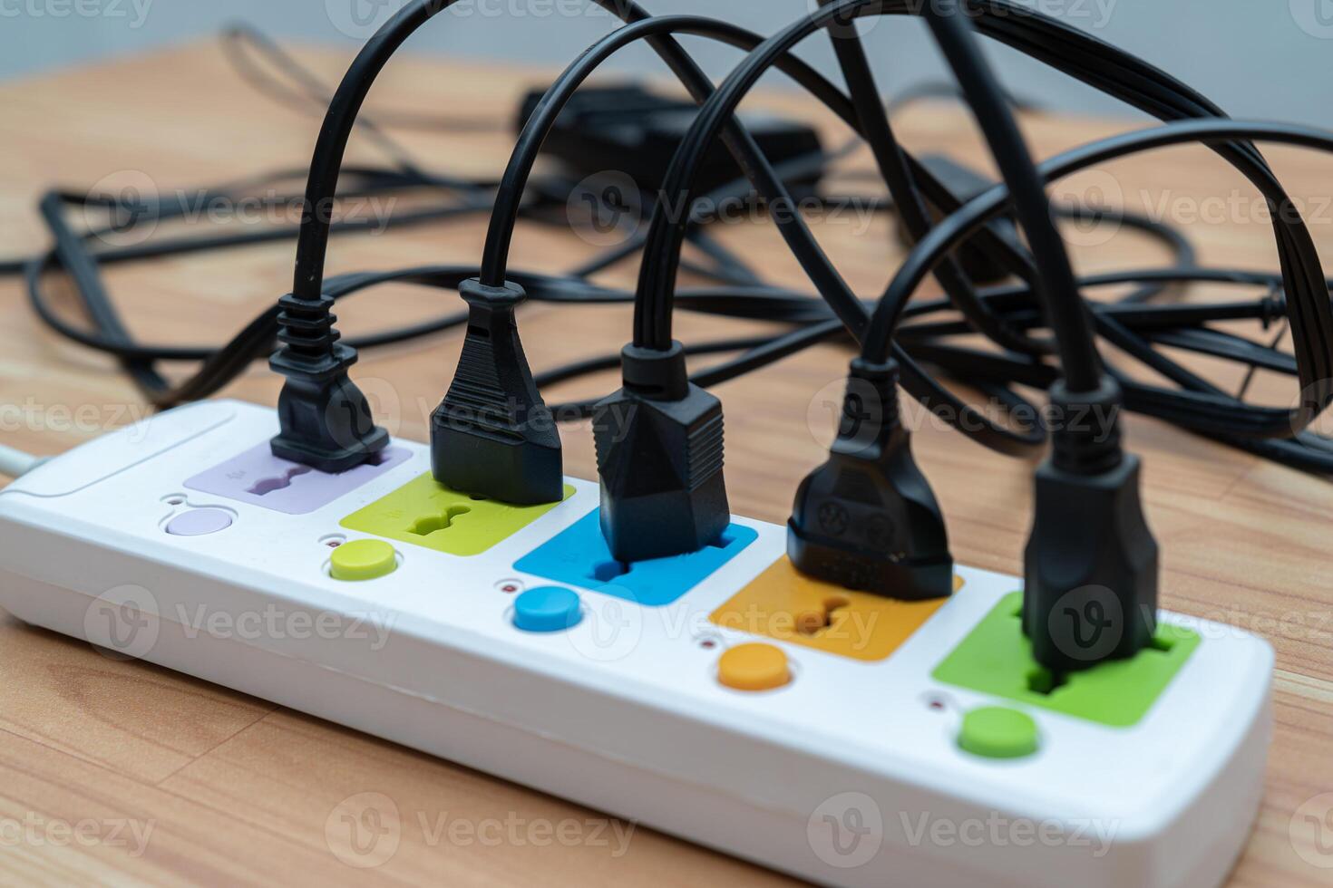 Many plugs connected to the power strip with individual switches. Surge protector with connected white wires of electrical appliances. Free space photo