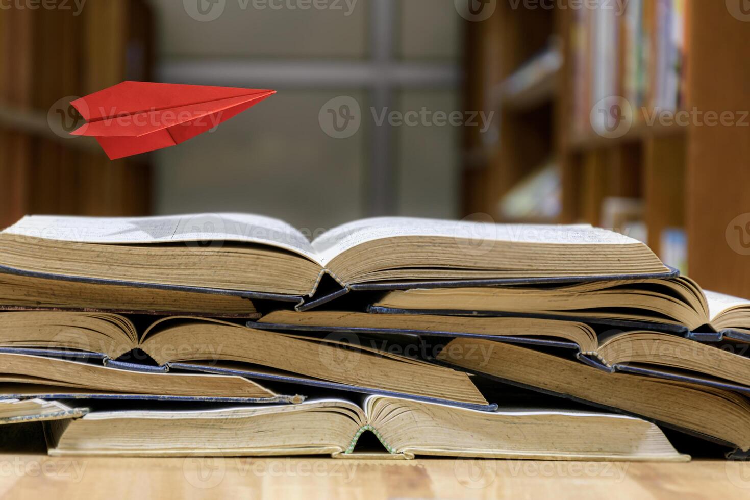 world book day flying paper plane imagination read. A paper airplane flies over a pile of old books open photo