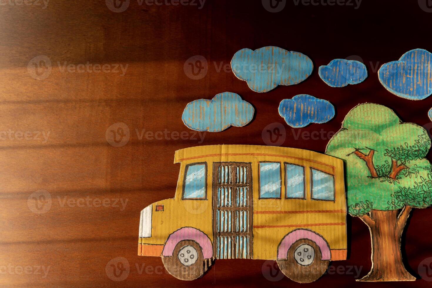 Yellow school bus made of cardboard and plants arranged on students' desks. Back to school concept. photo