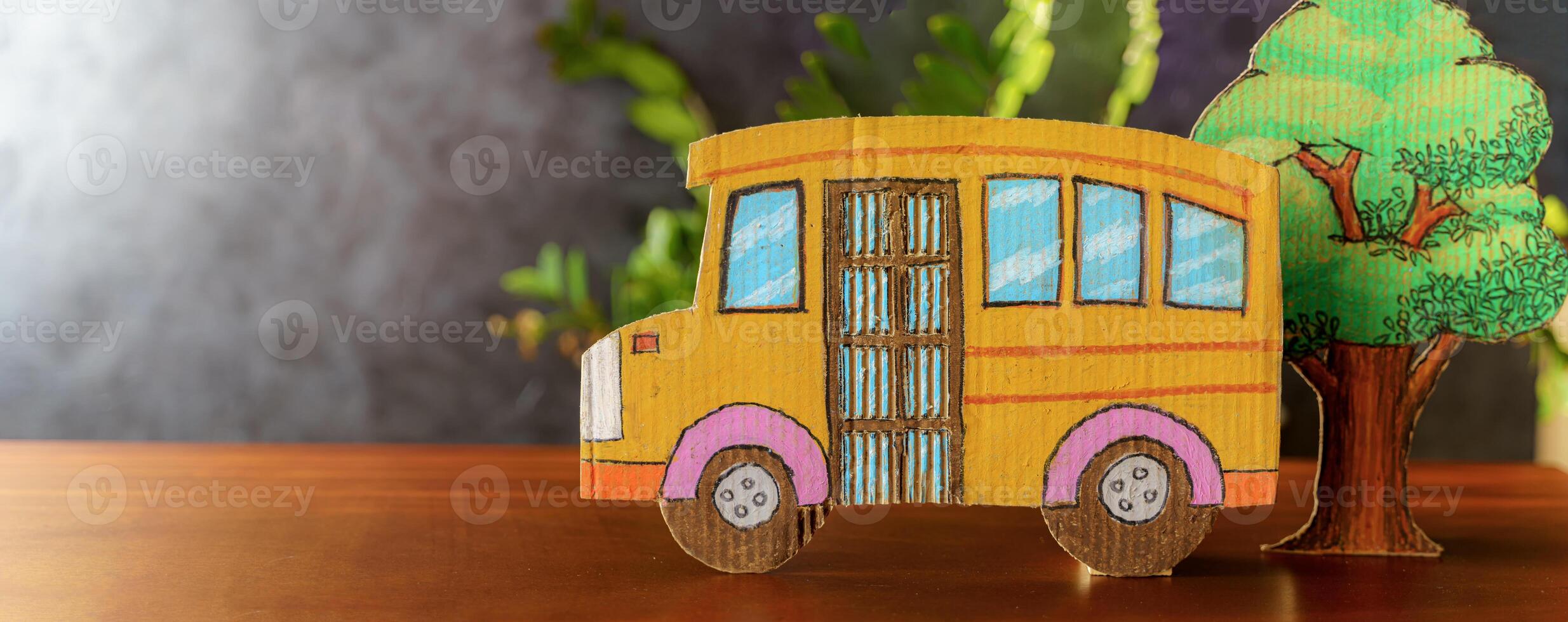 Education and back to school concept. Pencils stand as bus over wooden desk infront of classroom blackboard photo