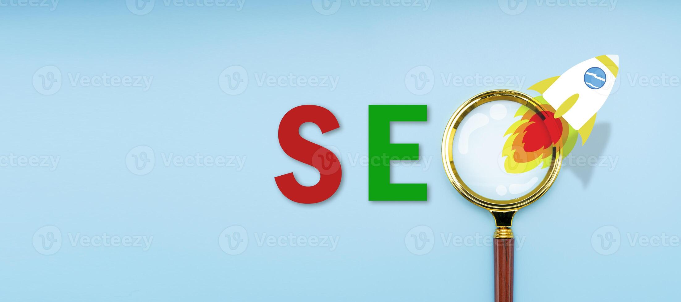 Magnifying glass on blue background. SEO rocket ejected analogy about internet analytics. Business, Technology, Internet and network concept photo