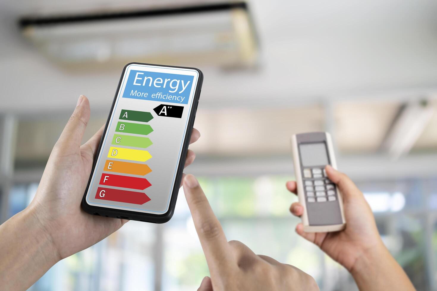 Hand holding digital smart phone and looking at house efficiency rating. Detail of house efficiency rating on digital tablet screen. Concept photo