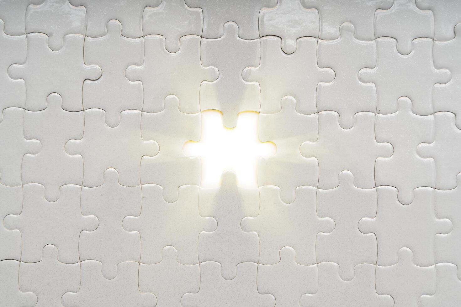 Solution concept. soft sun light ray coming through under a missing piece of jigsaw puzzle photo