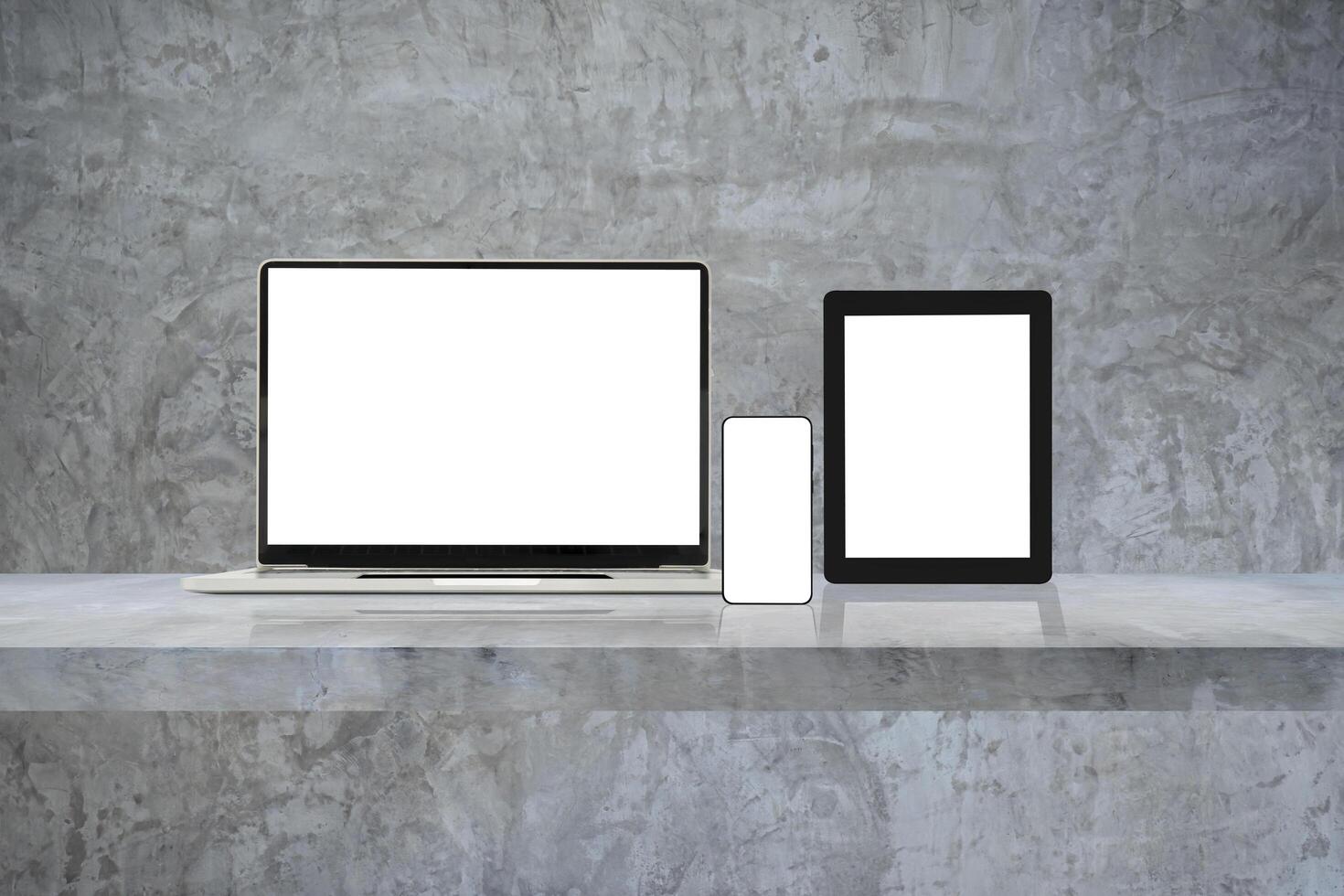 Laptop, mobile phone and digital tablet pc on grey wall shelf. photo