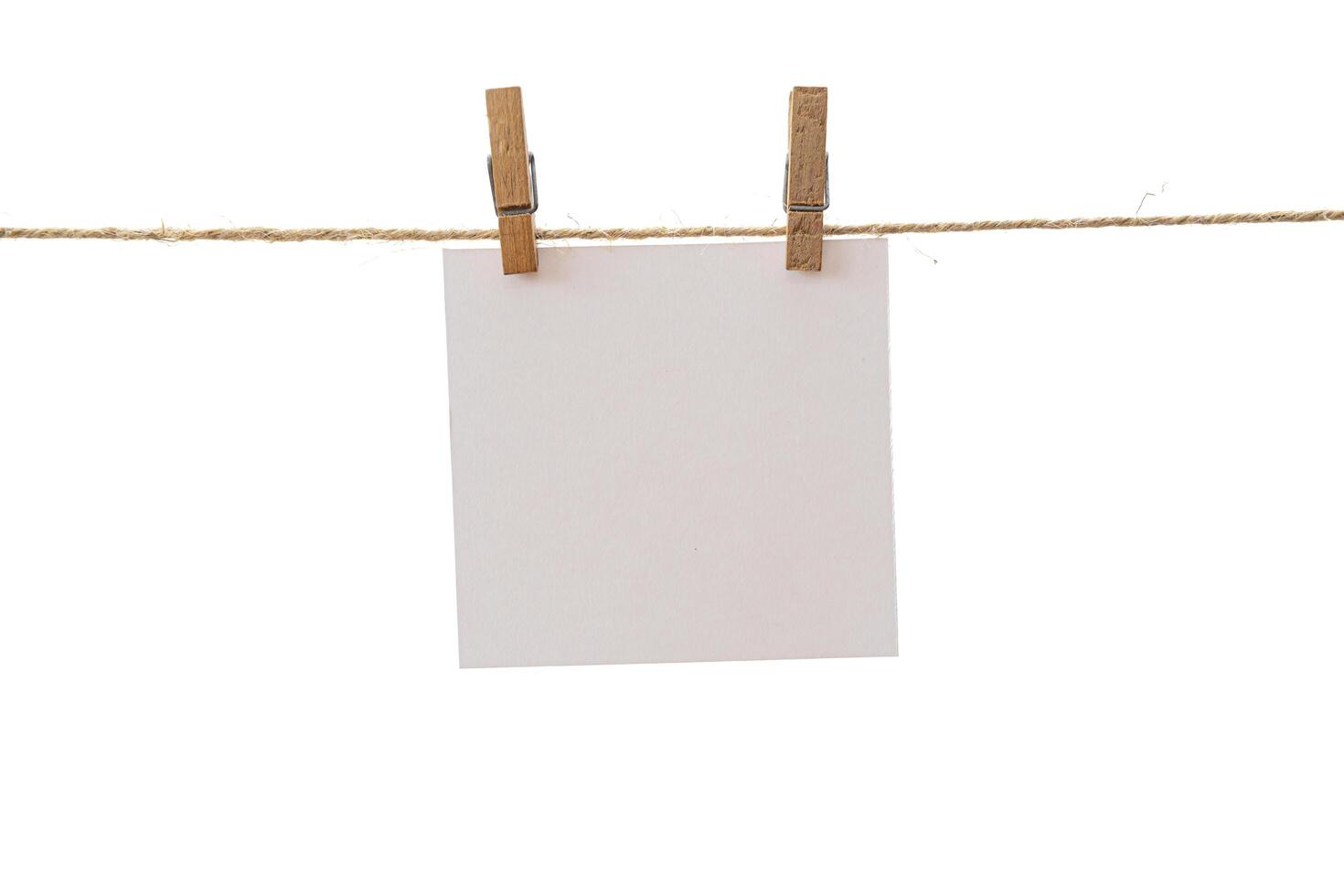Empty color paper sheets for notes, frames that hang on a rope with clothespins and isolated on white. photo