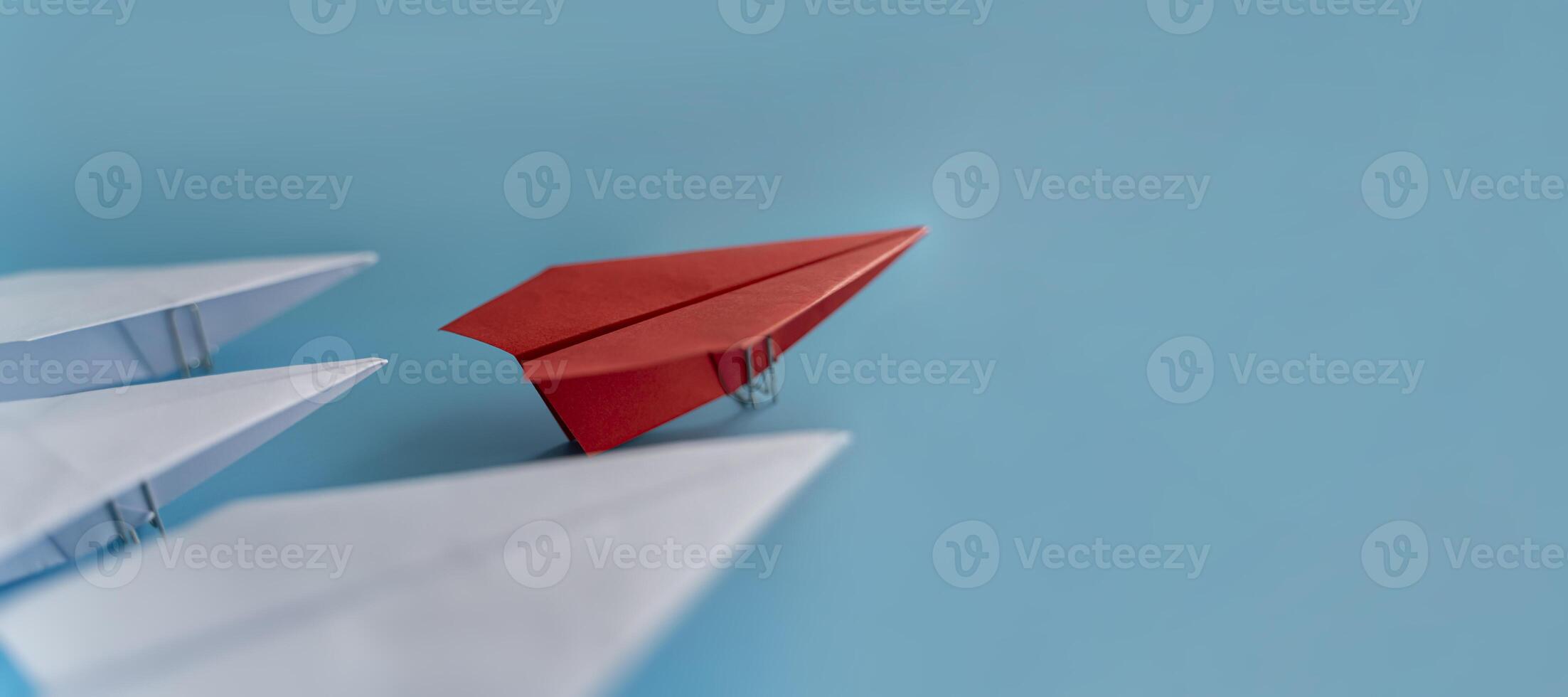 Red paper plane changing direction from white. New ideas. Different business concepts. Courage to risk. leadership. photo