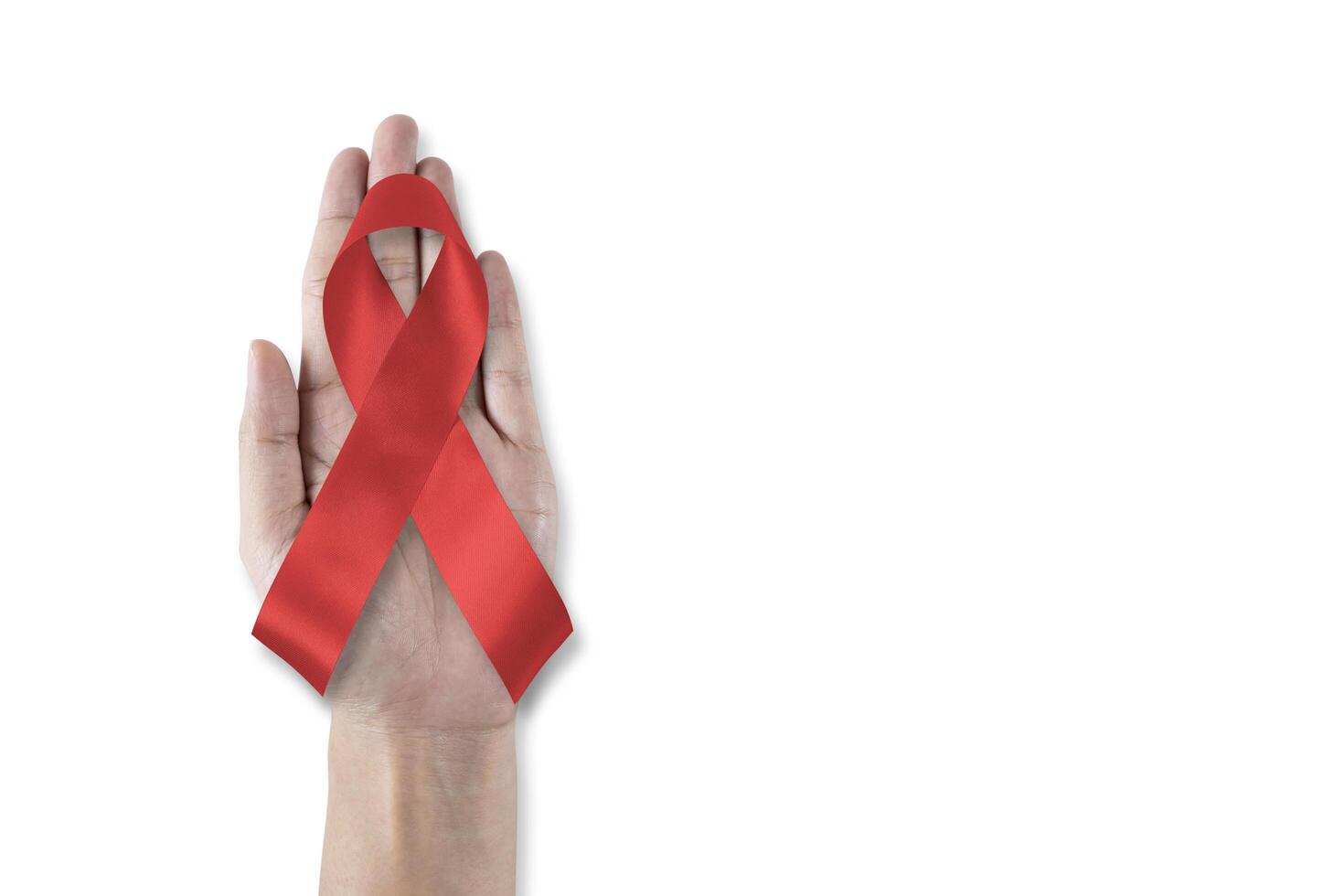 World aids day and national HIV AIDS and ageing awareness month with red ribbon on helping hand photo