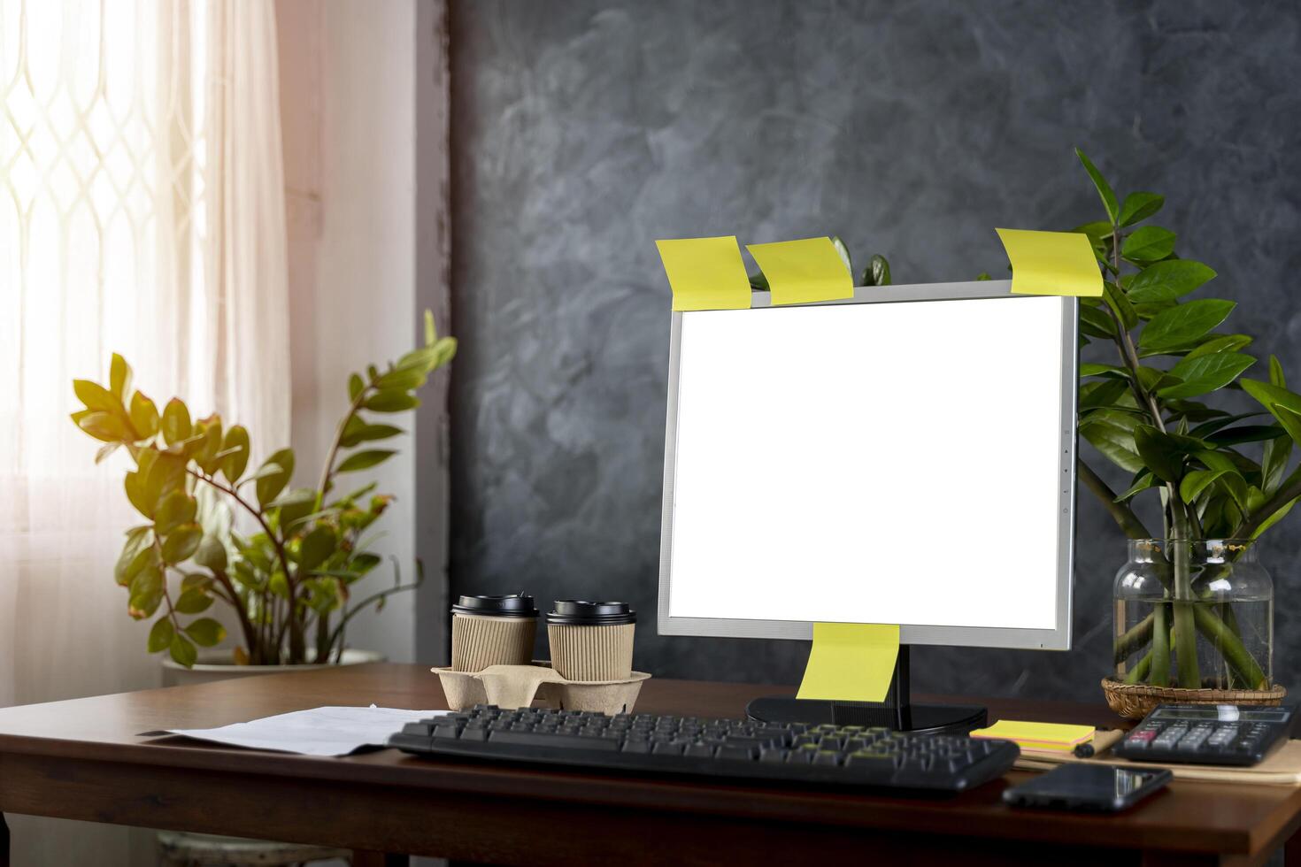 a computer with blank screen, lamp, plant, organizer and glasses, cup, mouse, three datebooks and pencils, Front view. Concept of work. photo