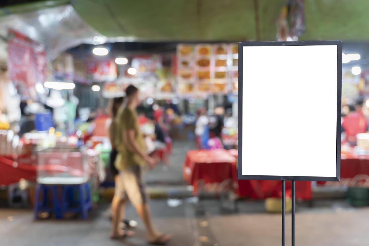 Empty poster frame template set in blur, walking market people. photo