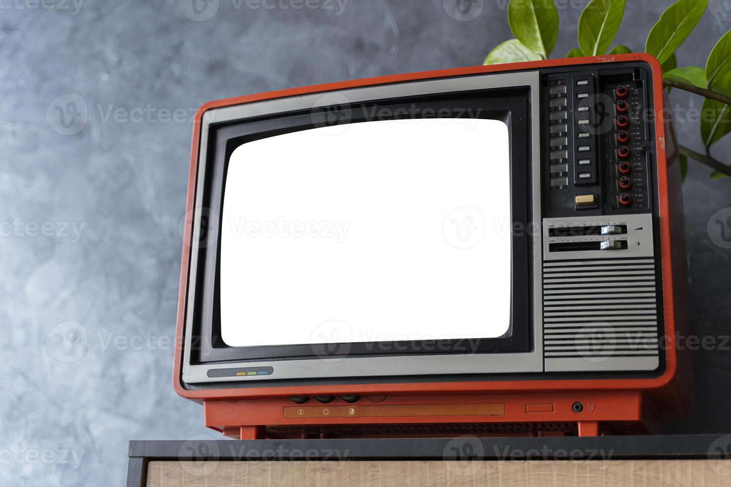 Old orange TV on a wooden cabinet in the room of the house, white background screen. Loft wall. Warm atmosphere. photo