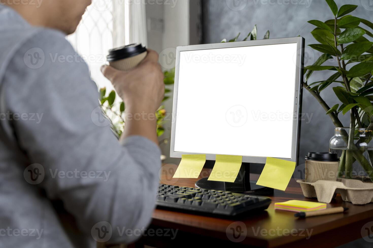 Concentrated businessman using computer watching online content at home. Blank white screen photo