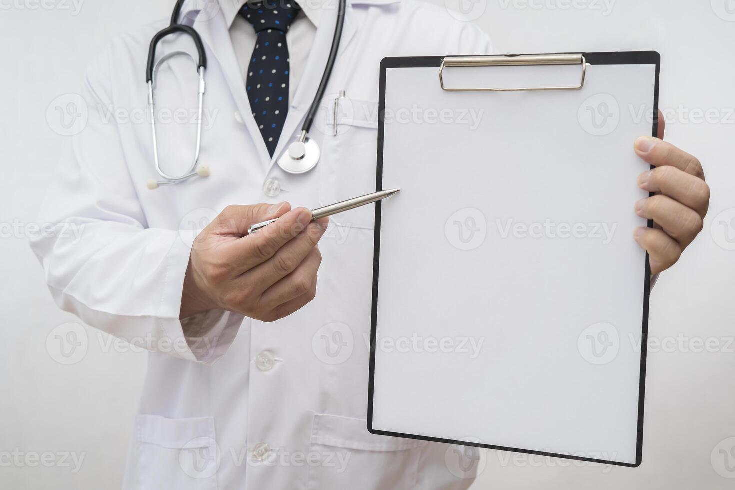 Doctor holding an empty clipboard with a pen pointing at the clipboard, can insert text, images photo