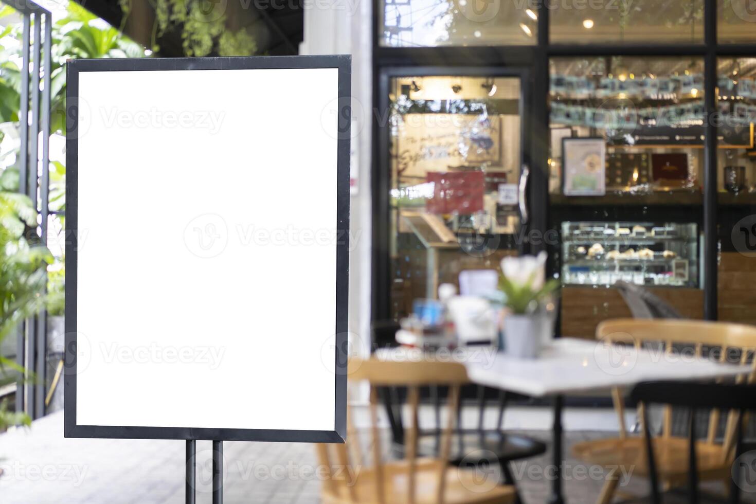 White blank signboard stand near the entrance to the coffee shop, mock up, cafeteria blurred background can inserting the text of the customer. photo