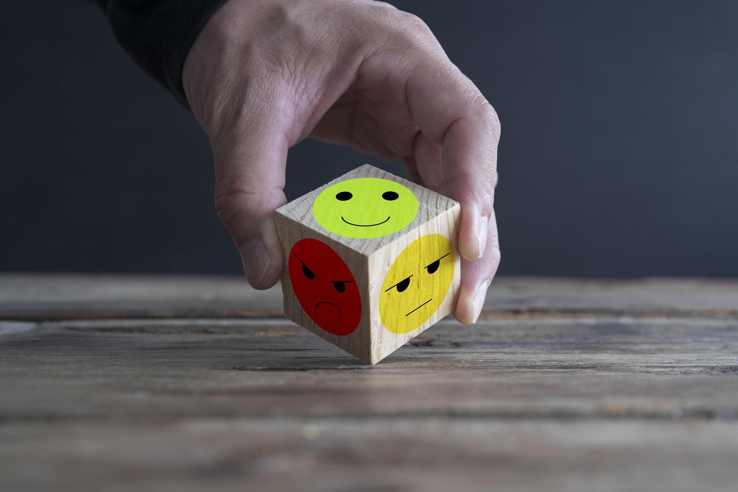 Businessman holds wooden blocks with sad and happy emotion icon emoticon set photo