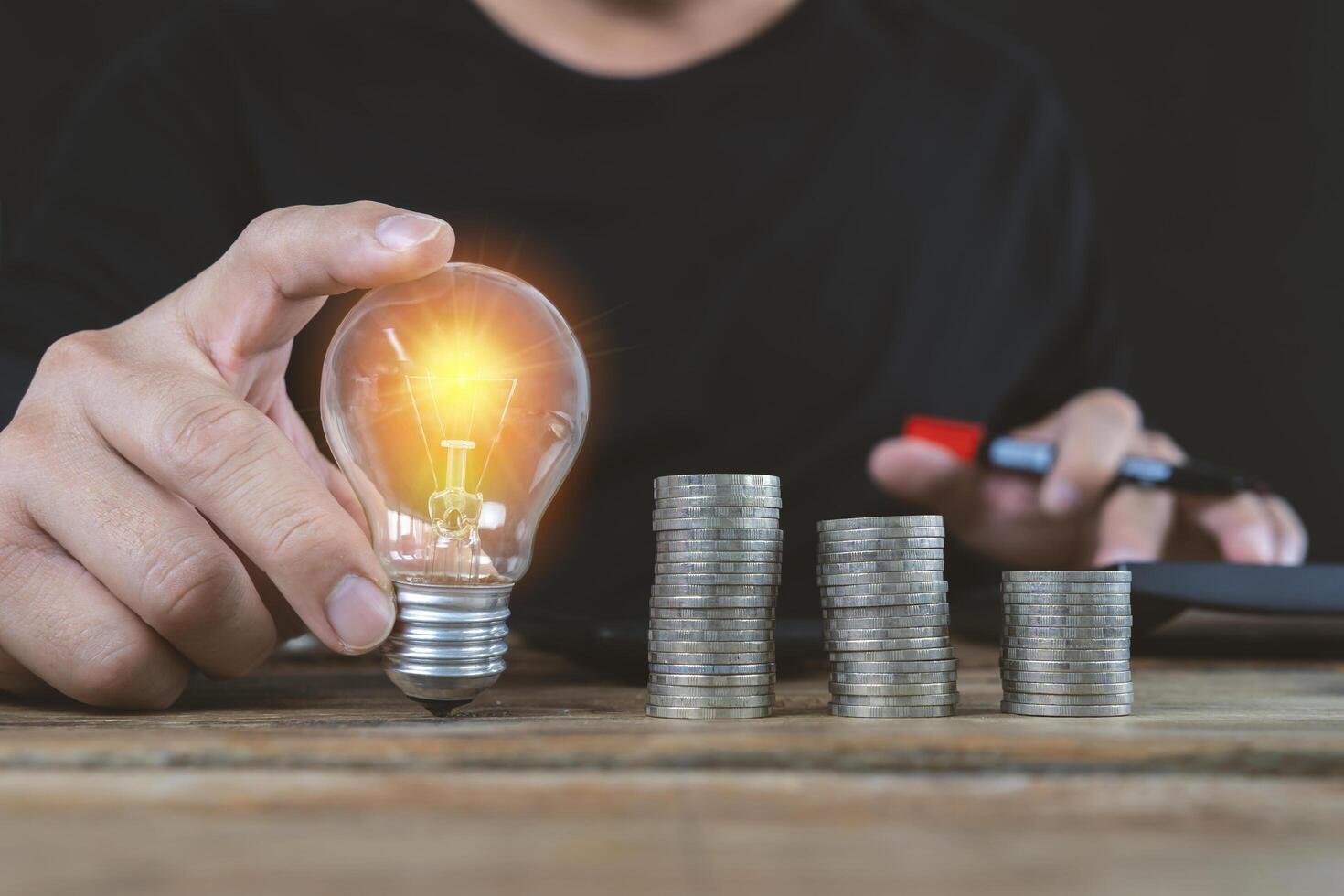 business accounting with saving money with hand holding lightbulb concept photo