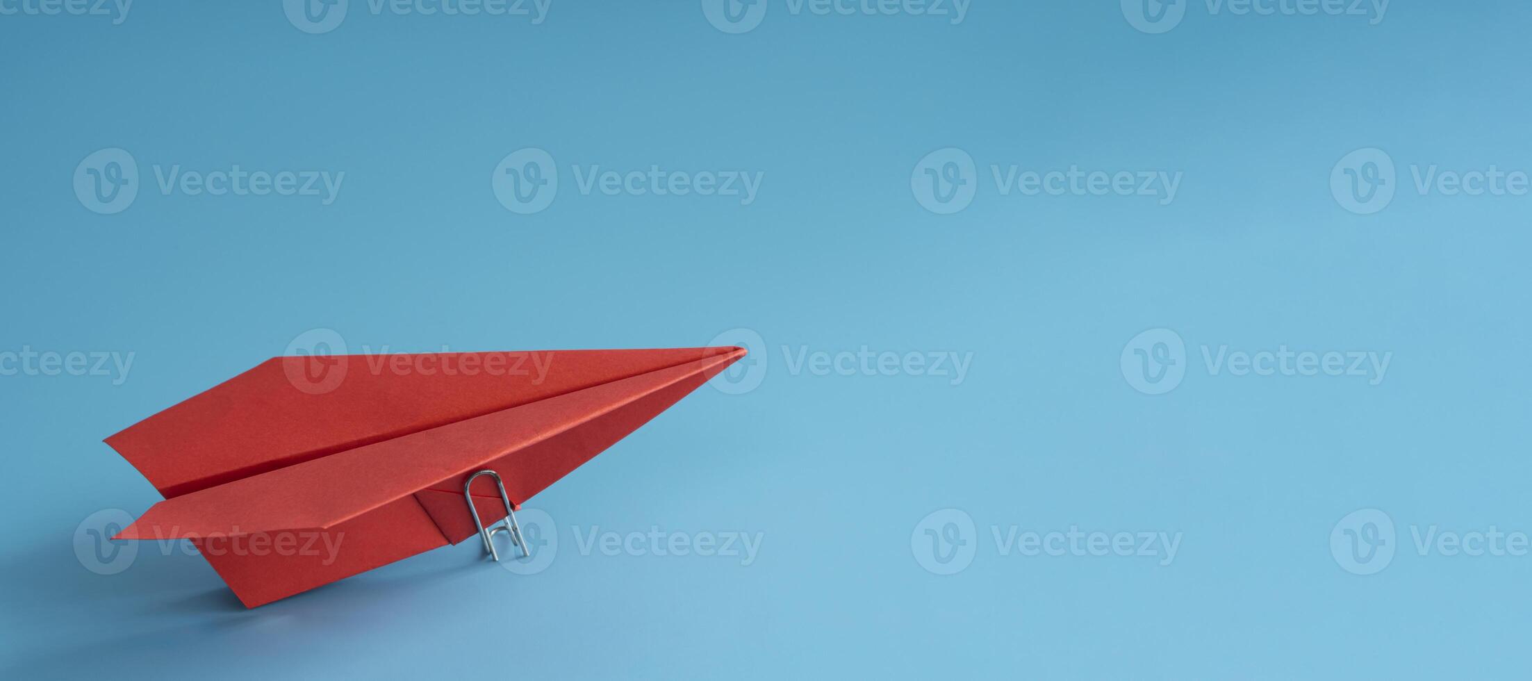 Red paper plane on blue background, top view. space for text, leadership concept. photo