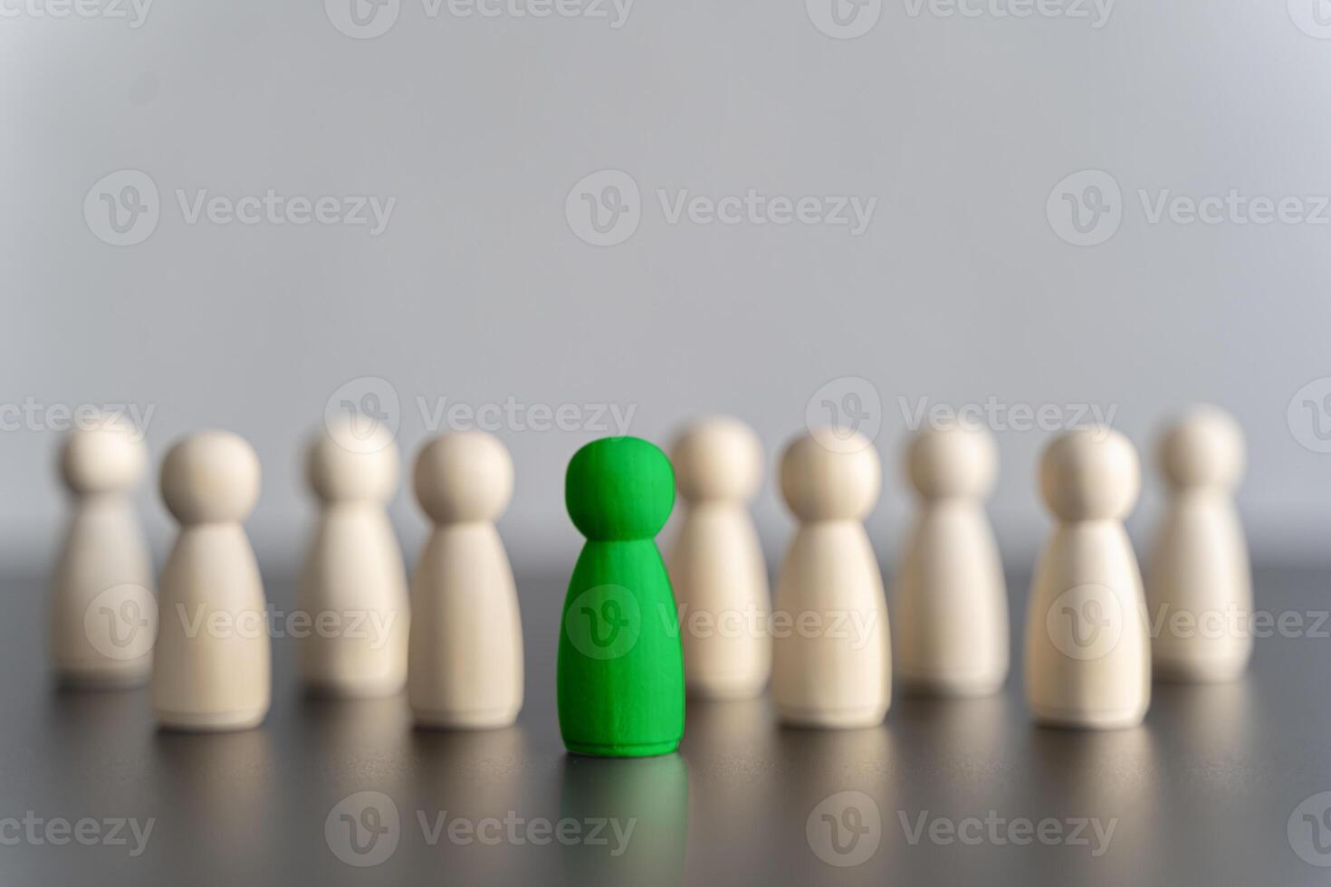 The green figure of a man comes out of the line of people. concept of success and improvement in work, the universal recognition of efficiency and leadership qualities. talent photo