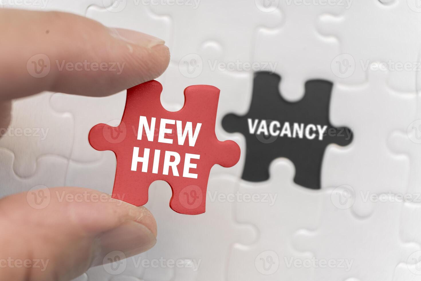 New hire words on a red puzzle piece filling a hole or open position on your staff or workforce. photo