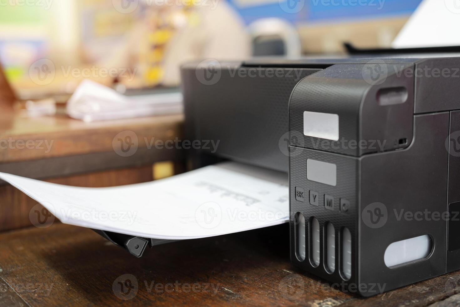 Teachers who are using a printer by ordering a print job via a laptop. photo