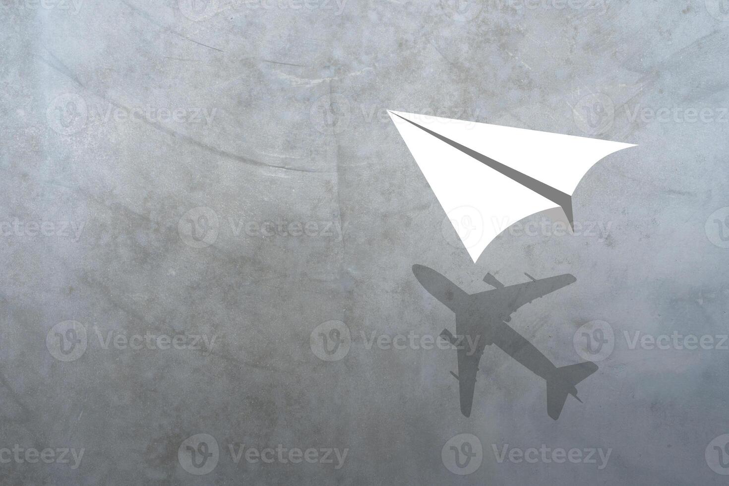 Paper plane in mid flight with shadow of a real plane photo