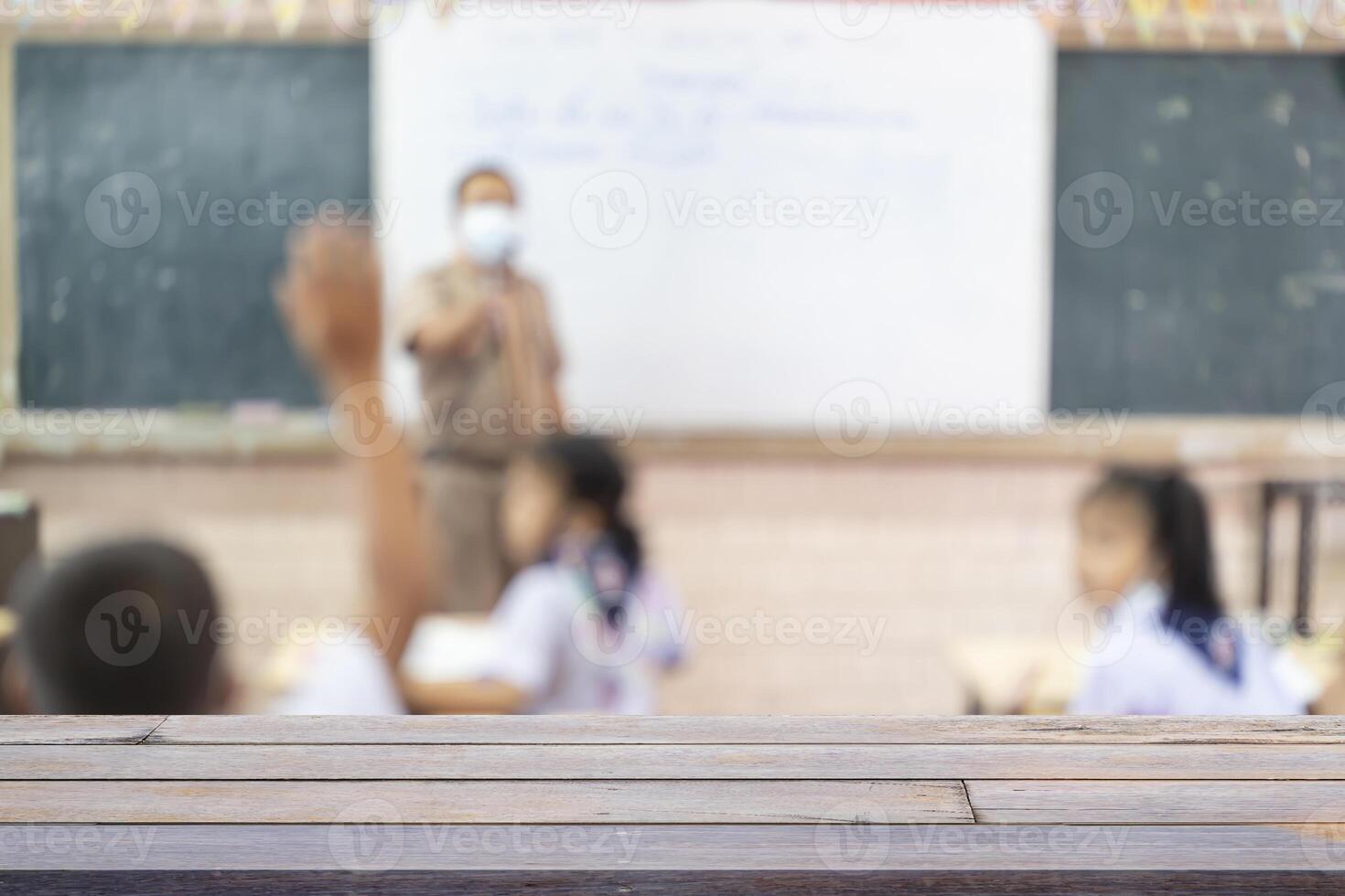Look out from the table. Kids with Teacher in the classroom, Blur Image For background. photo
