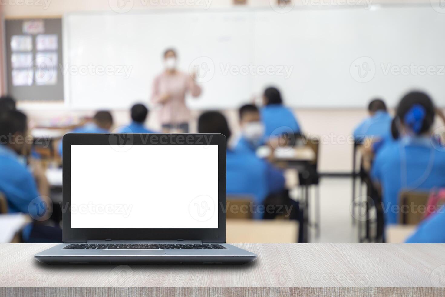 Computer on the table, blur image of the children classroom photo