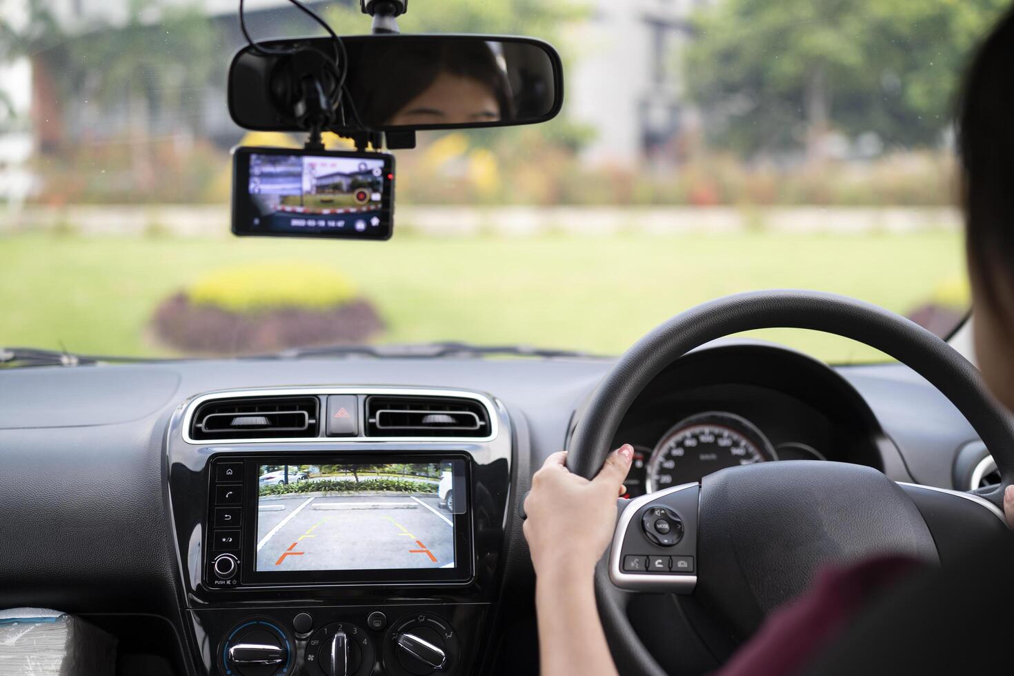Woman driving in reverse and using a rear view camera in her car photo