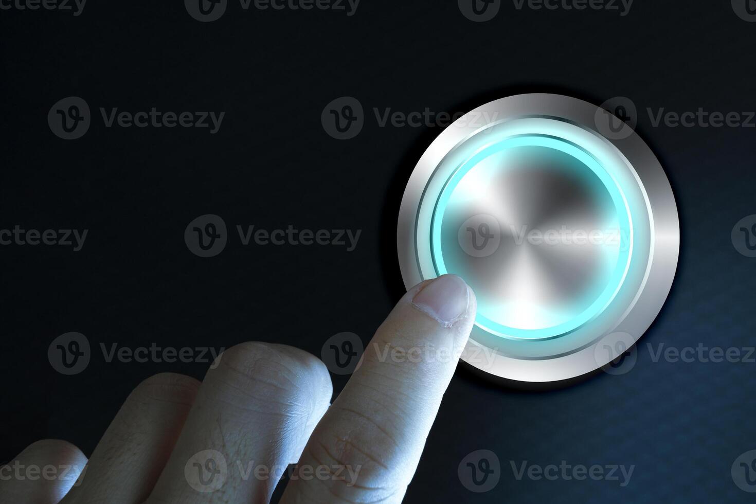 Finger about to press button with blue light over black and grey background. photo