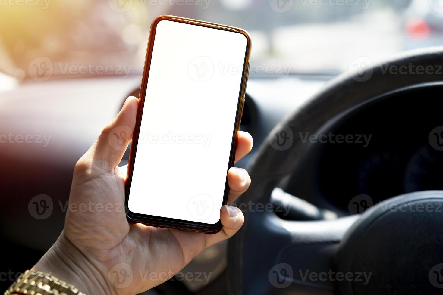 The driver uses the phone while driving. Modern smart phone with round edges. photo