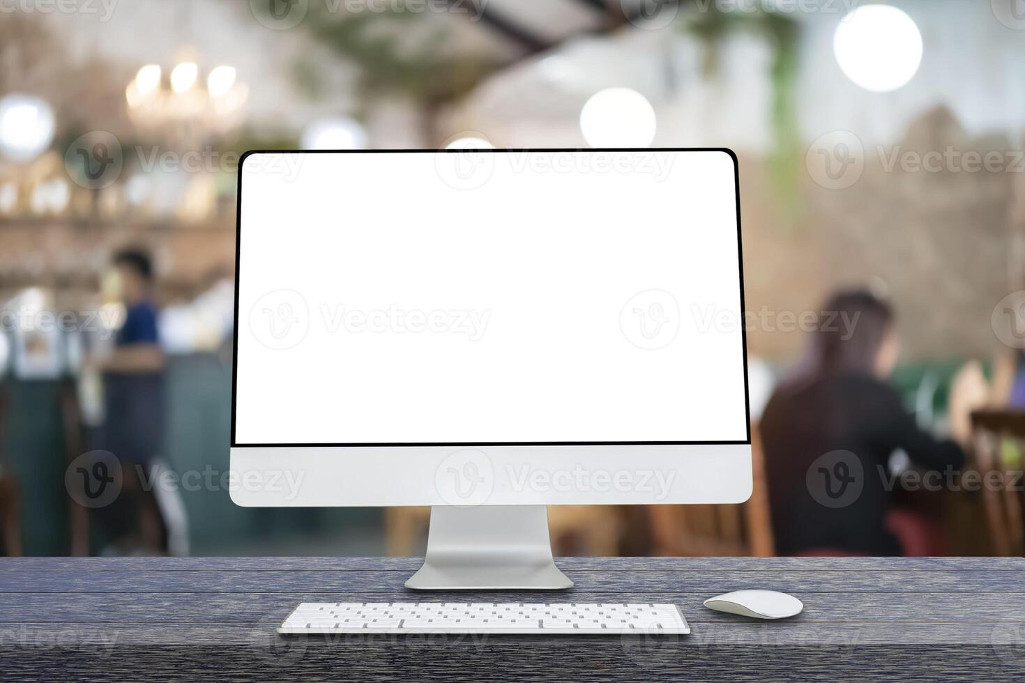 Computer monitor with white blank screen putting on wooden working desk, blurred restaurant as background. photo