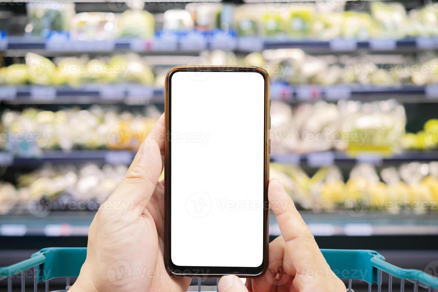 someones hand holding mobile smart phone with empty screen on supermarket blur background photo