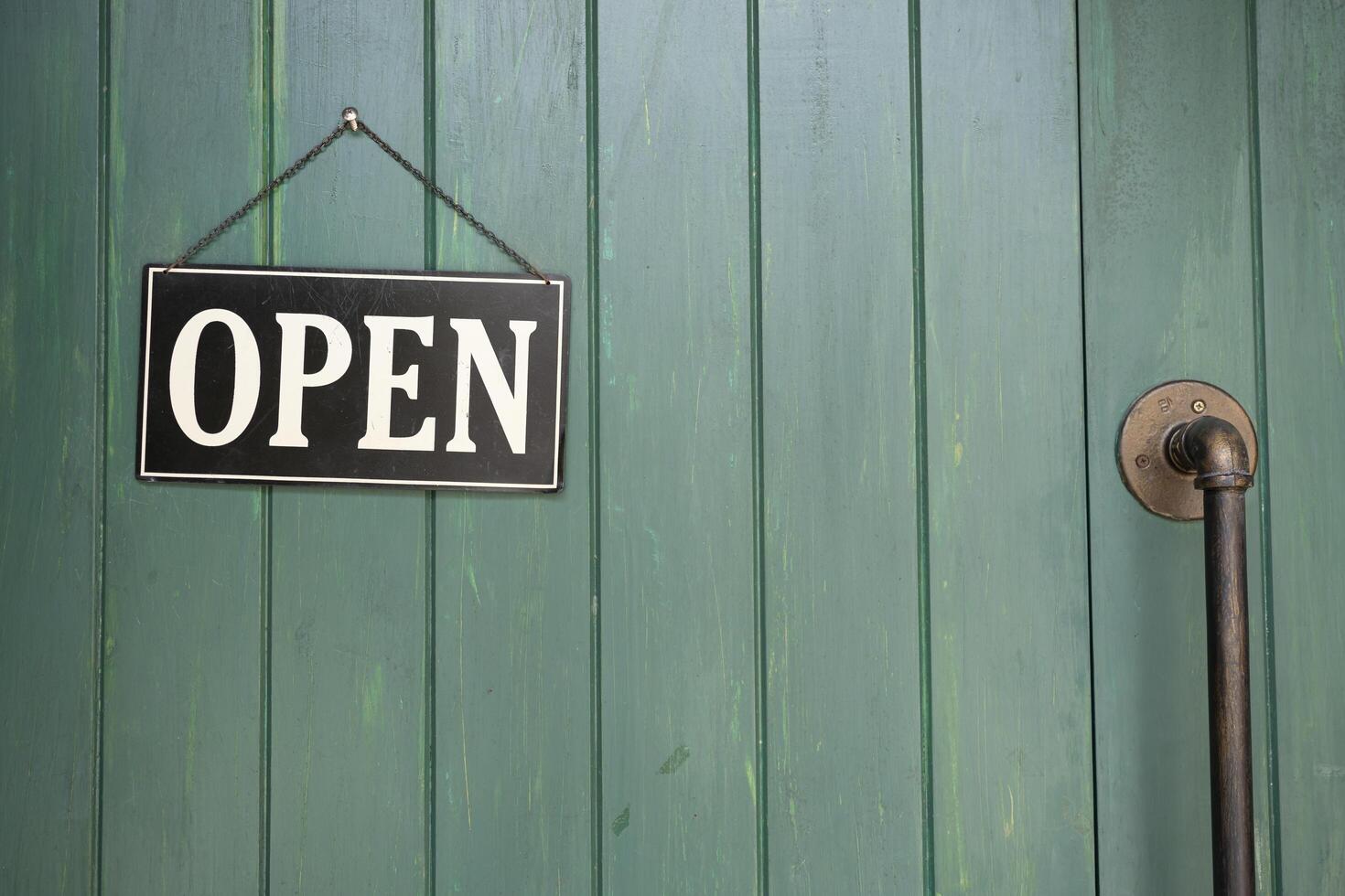 A business sign that says Open on cafe or restaurant hang on door at entrance photo