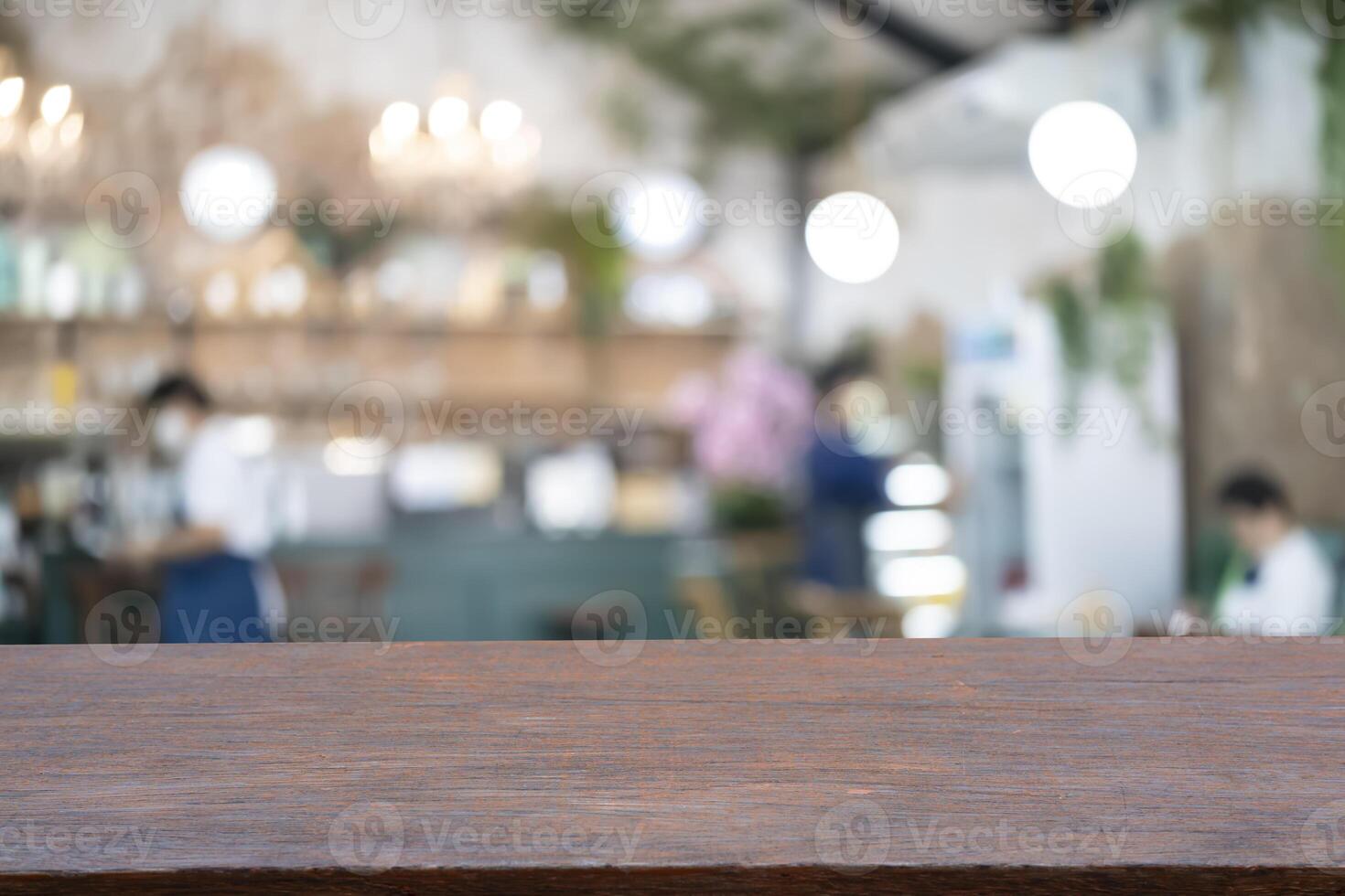Wood table top with blur of people in coffee shop photo