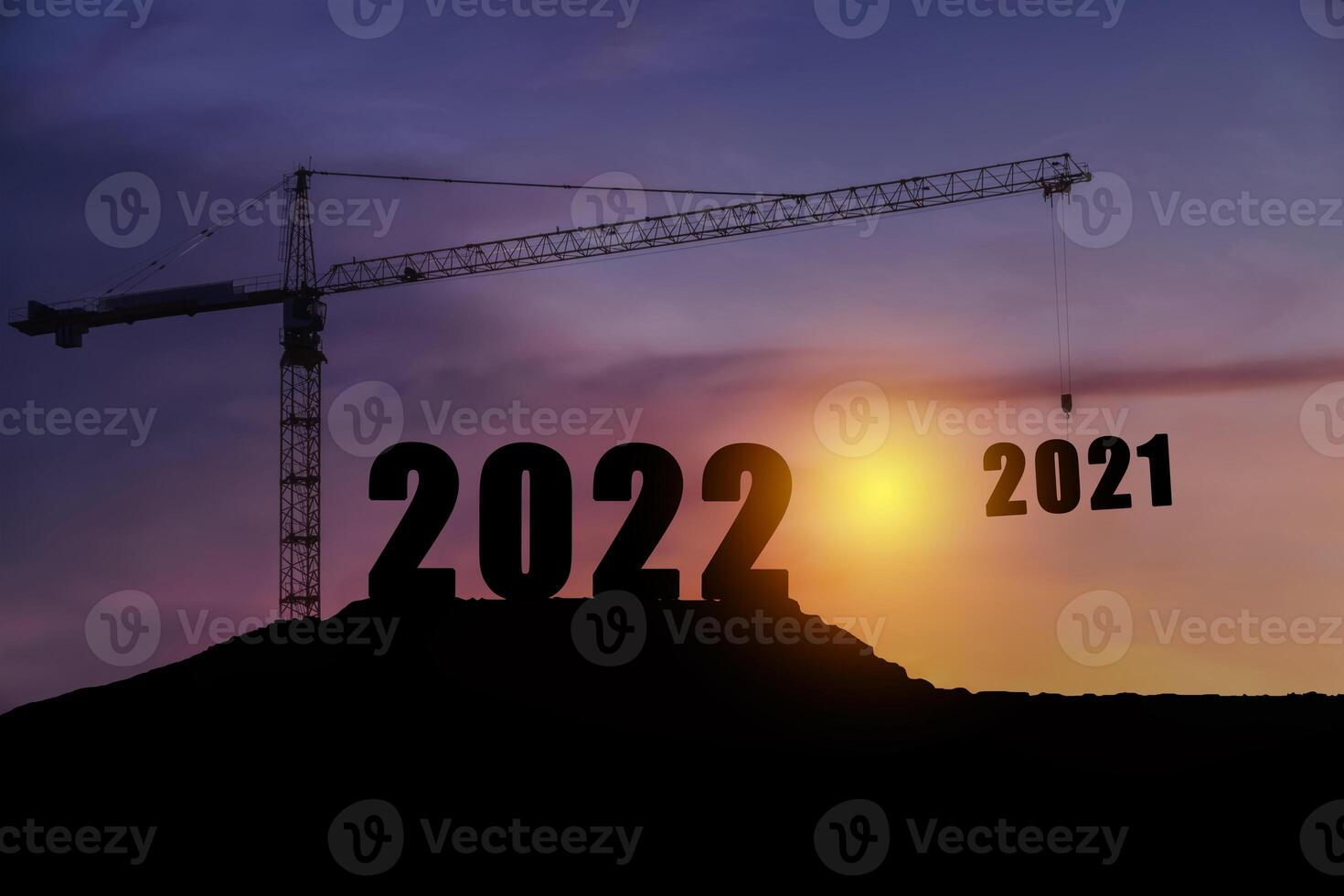 Silhouette of engineer and construction to create lifting crane 2022 on blue sky background. photo